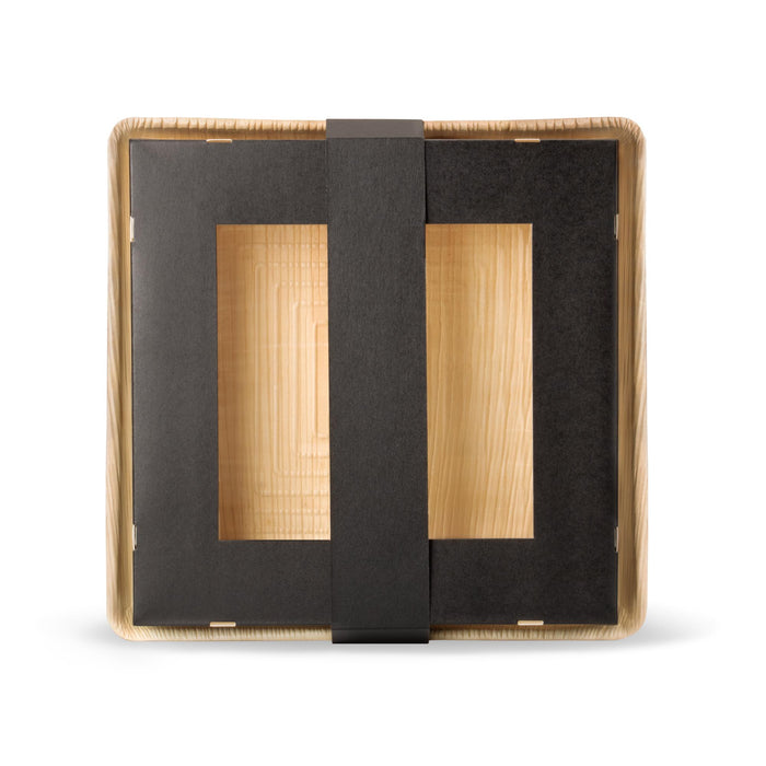 Dreiteilige, quadratische Take-Away-Box aus Kraftpapier und Palmblatt. Die hellbeige Bodenplatte dient als Basis für eine schwarze Papierbox mit Sichtfenster, die durch einen Papierring verschlossen wird.